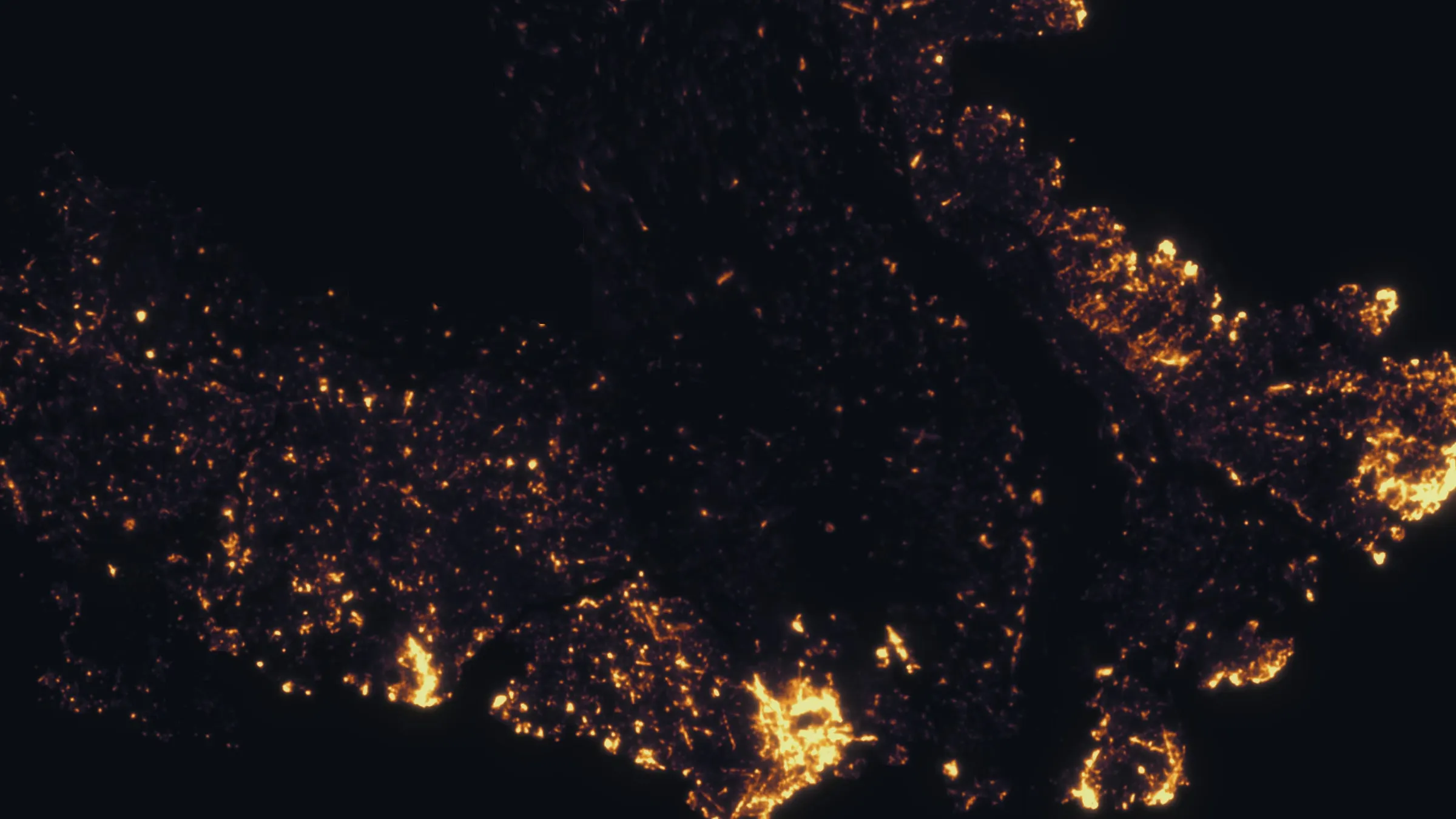 Night thermal map of a wildland fire, hundreds of individual heat sources glowing against cold dark ground.